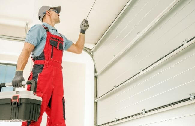 Garage Door Guys Sydney carrying out garage door panel replacement with a technician checking the alignment of the new panels.