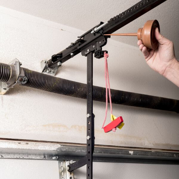 Garage door servicing in Sydney, technician lubricating the opener rail for smooth and quiet operation by Garage Door Guys Sydney