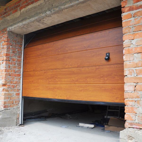 Modern timber-look sectional garage door being inspected during garage door servicing by Garage Door Guys Sydney.